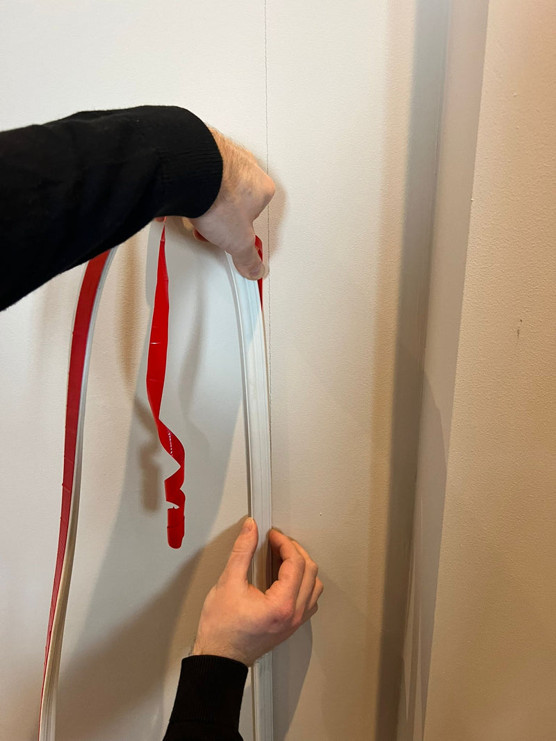 De sierlijst wordt afgeplakt op de muur