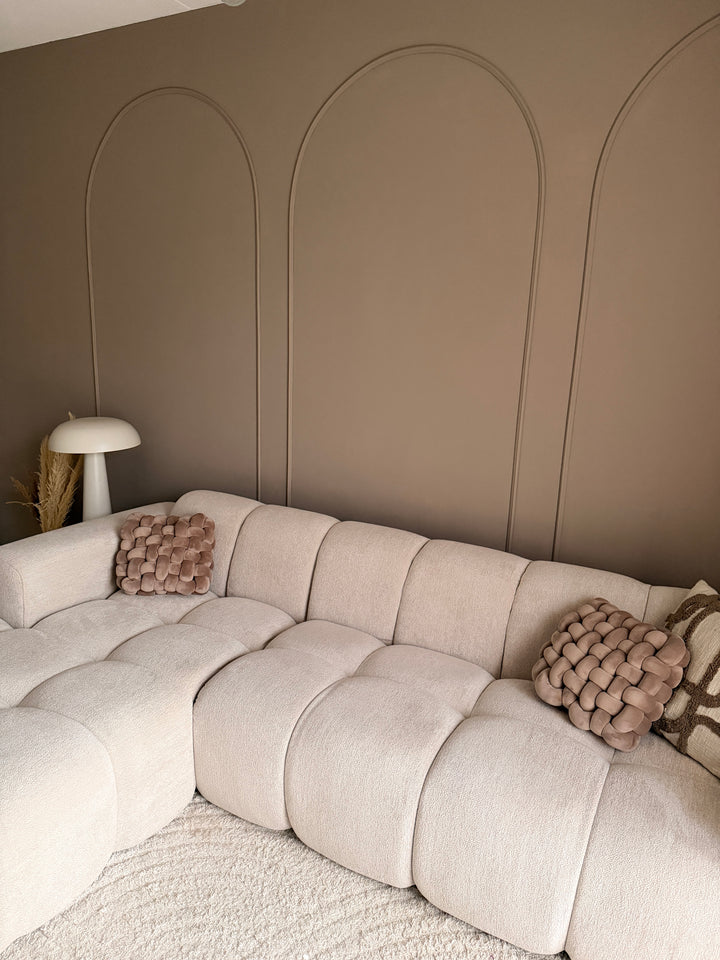 Woonkamer inspiratie met drie grote wandbogen gemaakt van flexibele sierlijsten achter een ruime, comfortabele zithoek